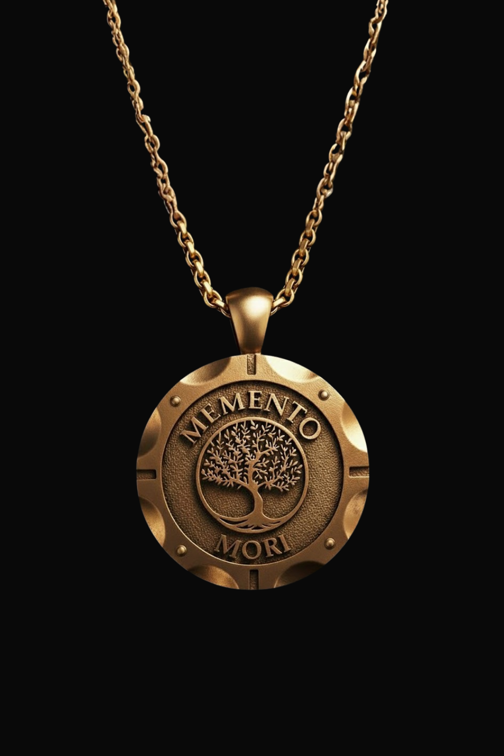 A gold-colored pendant necklace with a circular medallion featuring the Latin motto "Memento mori" (which means "Remembering" or "Remembering") and a tree design.