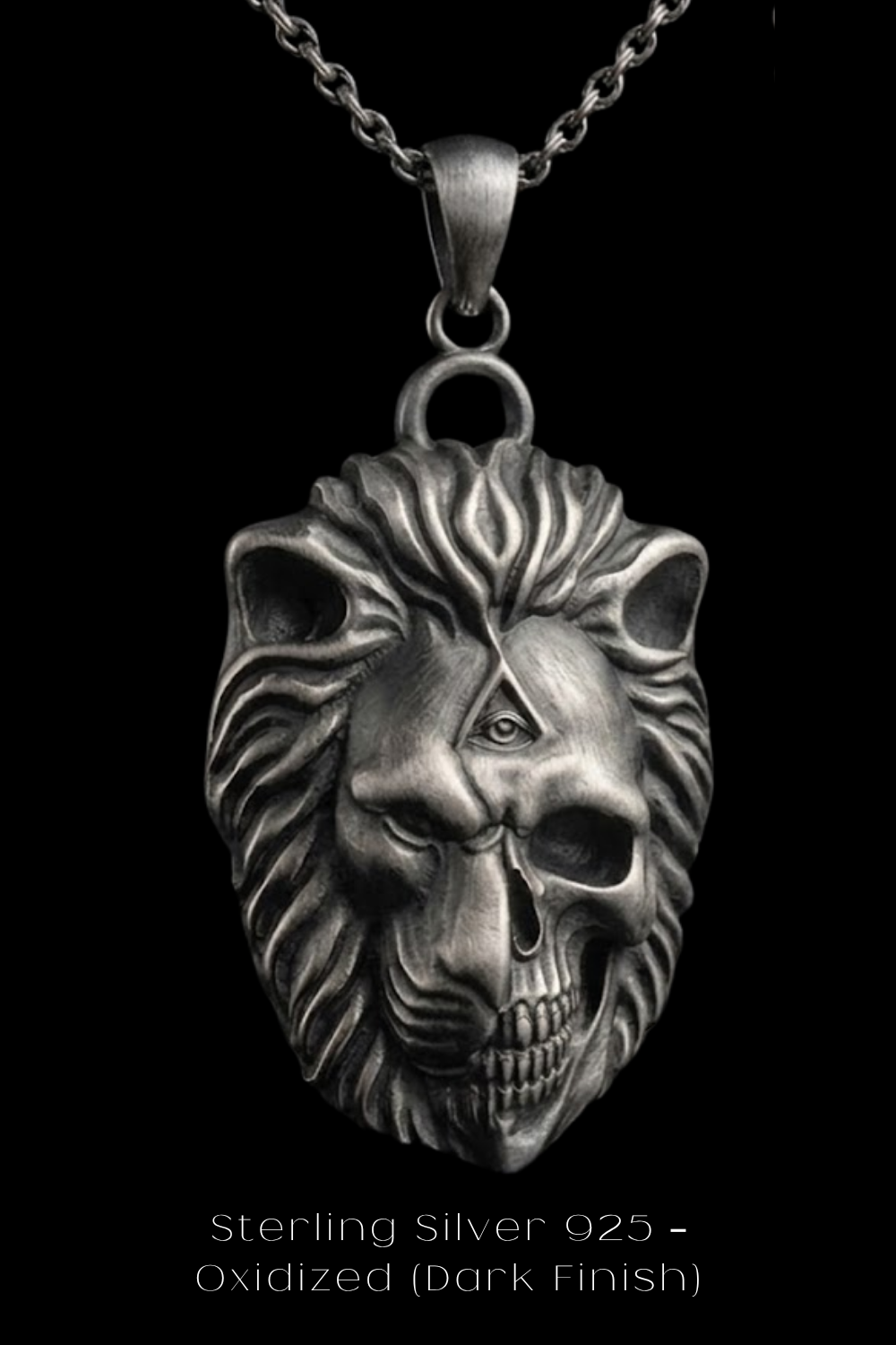 A silver pendant in the shape of a lion's head with a skull-like design, suspended from a chain against a black background.