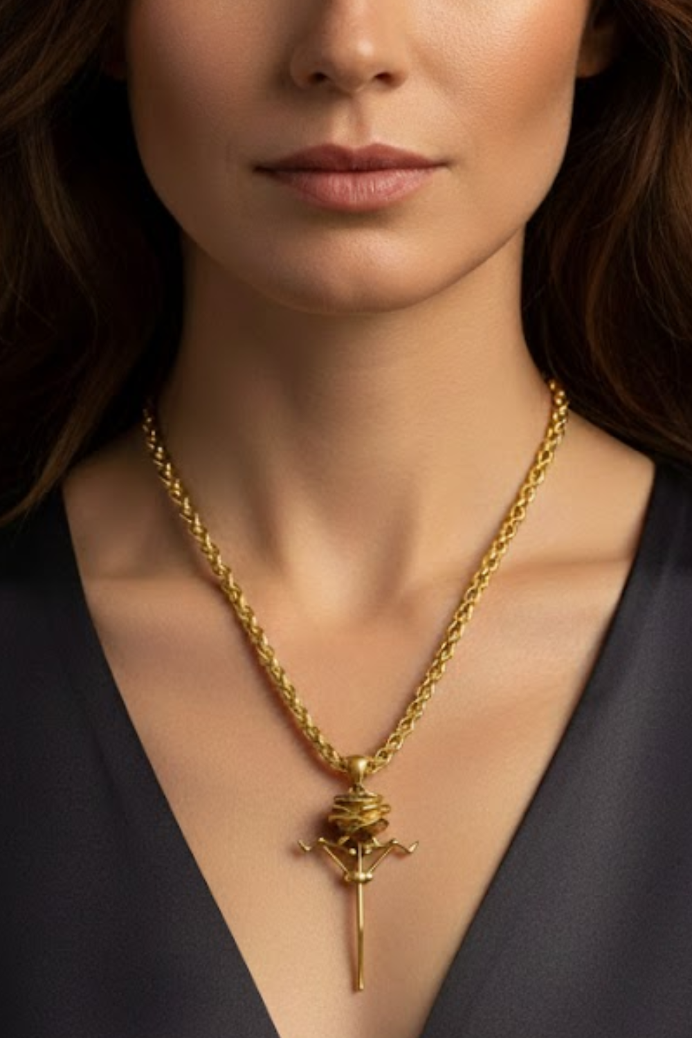 A close-up of a woman's neck and chest area wearing a gold necklace with a pendant.
