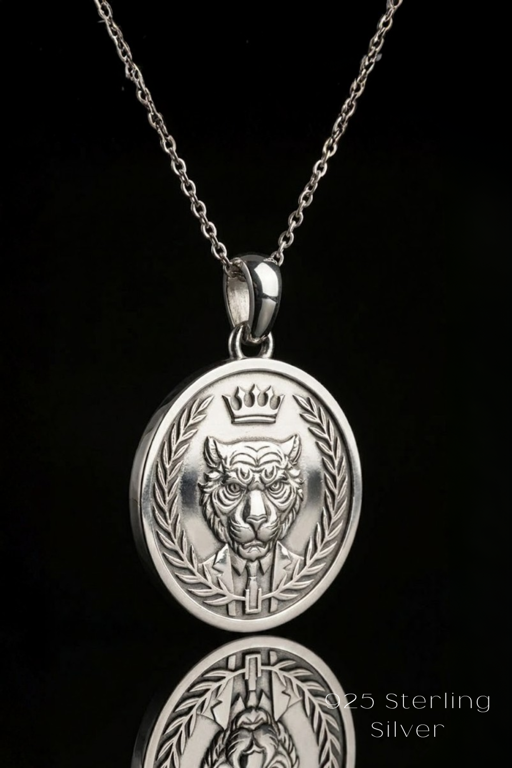 A silver pendant necklace with a circular medallion featuring a lion's head and crown design.