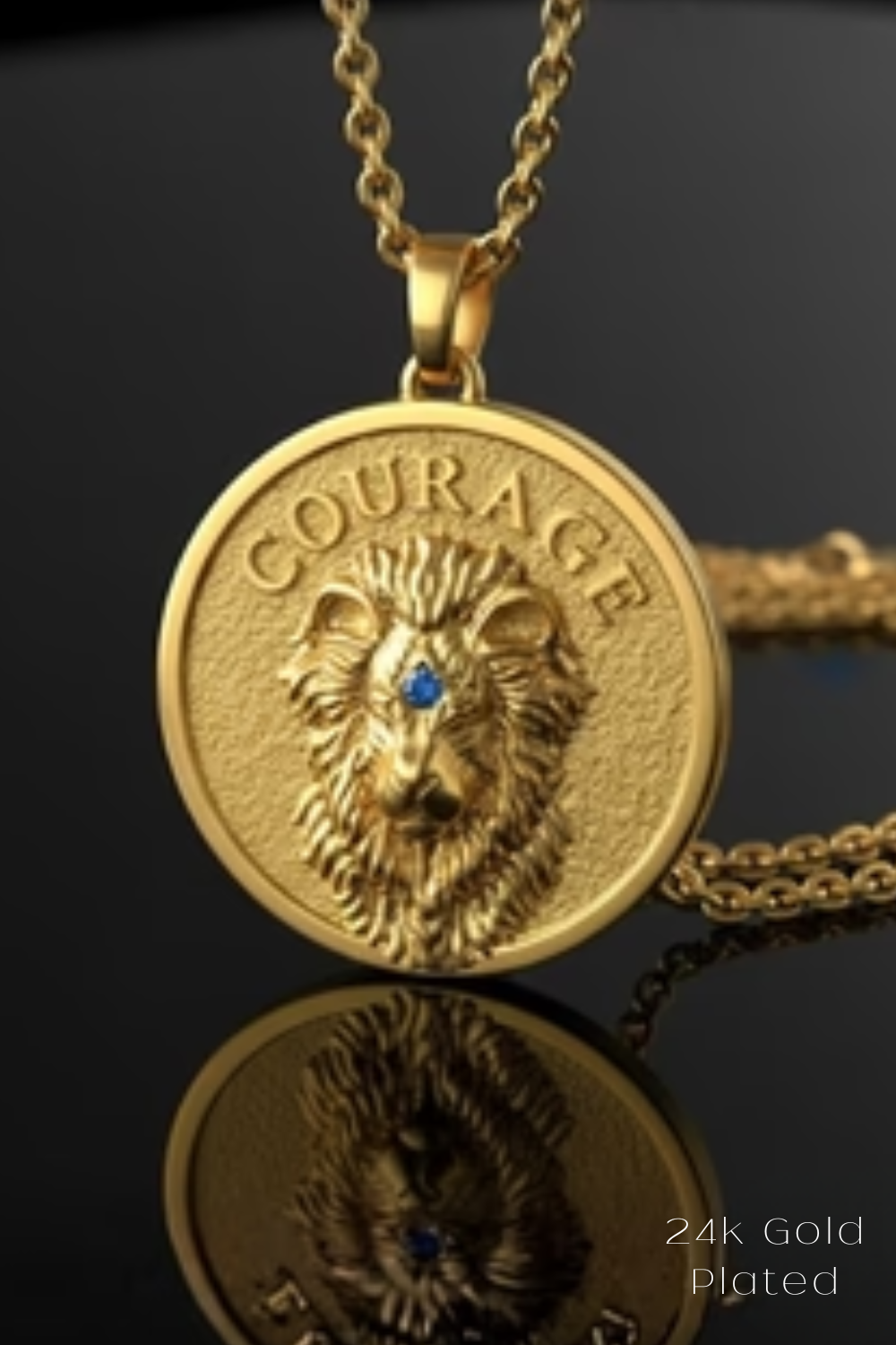 A gold-colored pendant necklace with a lion's head design and the word "COURAGE" engraved on it.