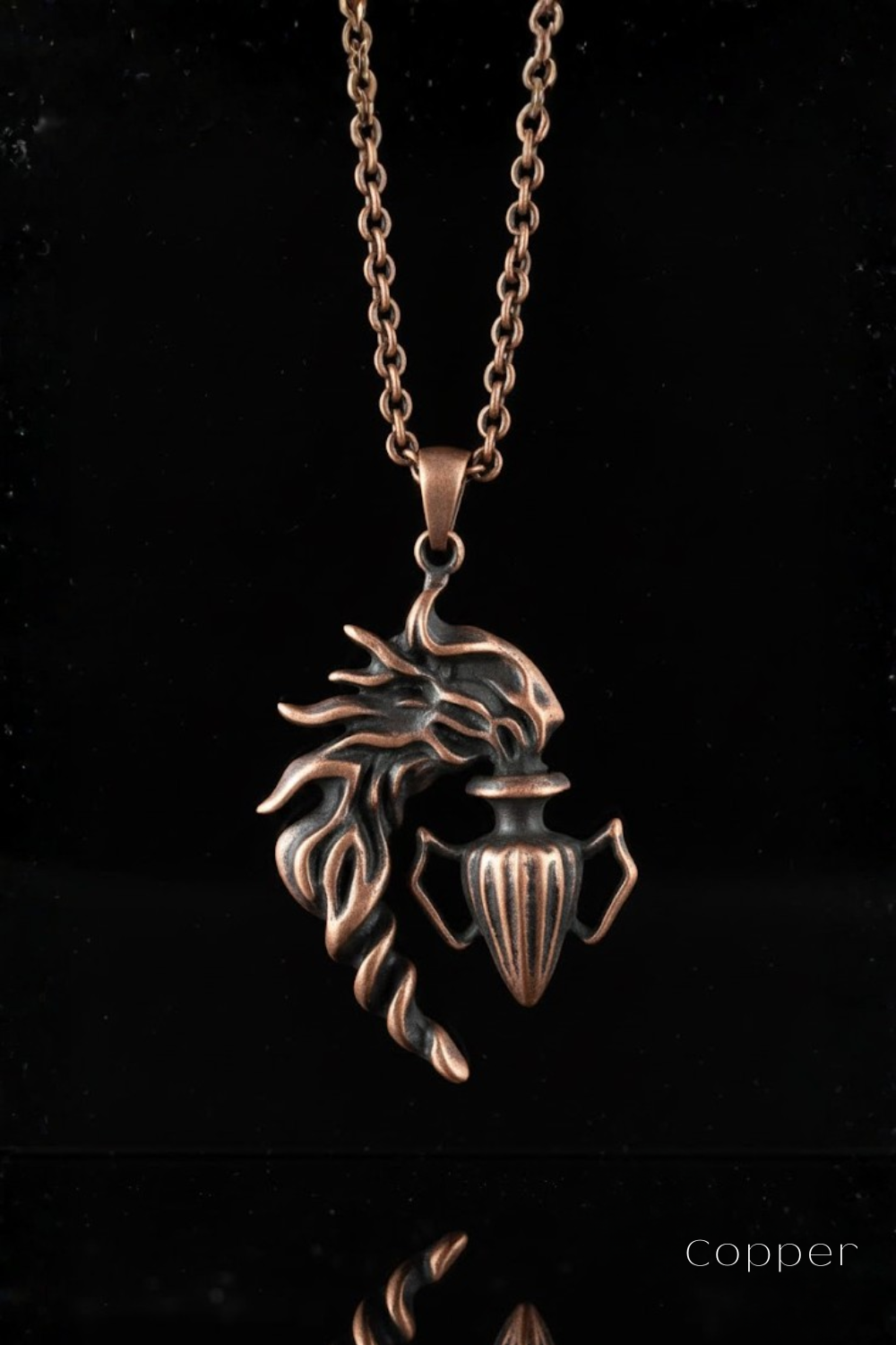 A copper-colored pendant necklace with a stylized design, featuring a flame-like element and a vase-like shape.