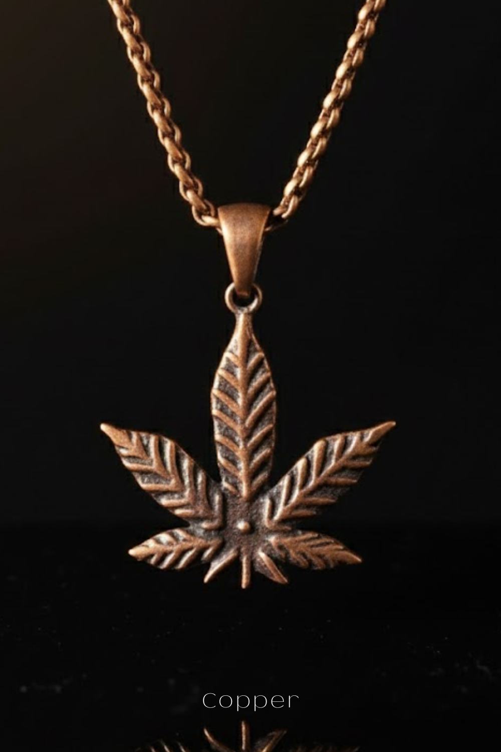 A copper-colored pendant necklace with a detailed leaf-shaped design.