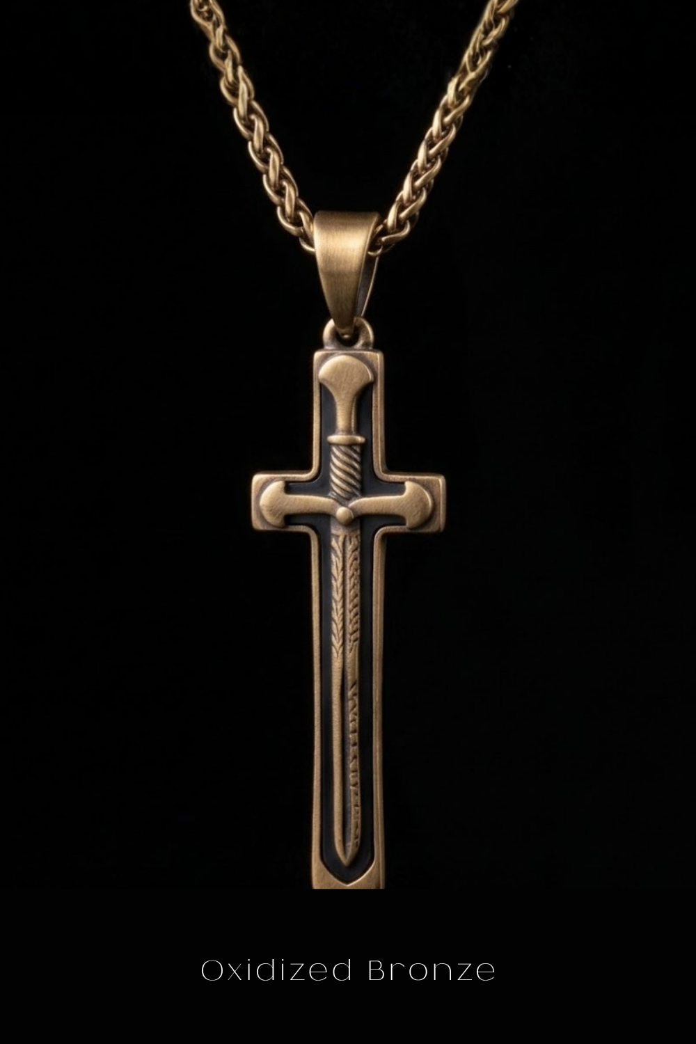 A gold-colored pendant with a cross design and a sword-like element, suspended from a chain against a black background.
