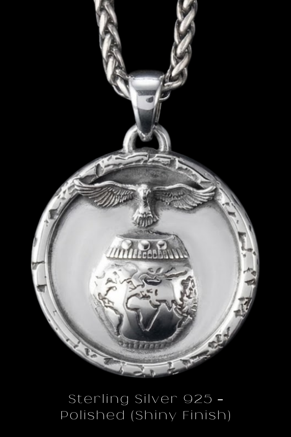 A silver pendant with a circular design featuring a bird, a globe, and a chain.