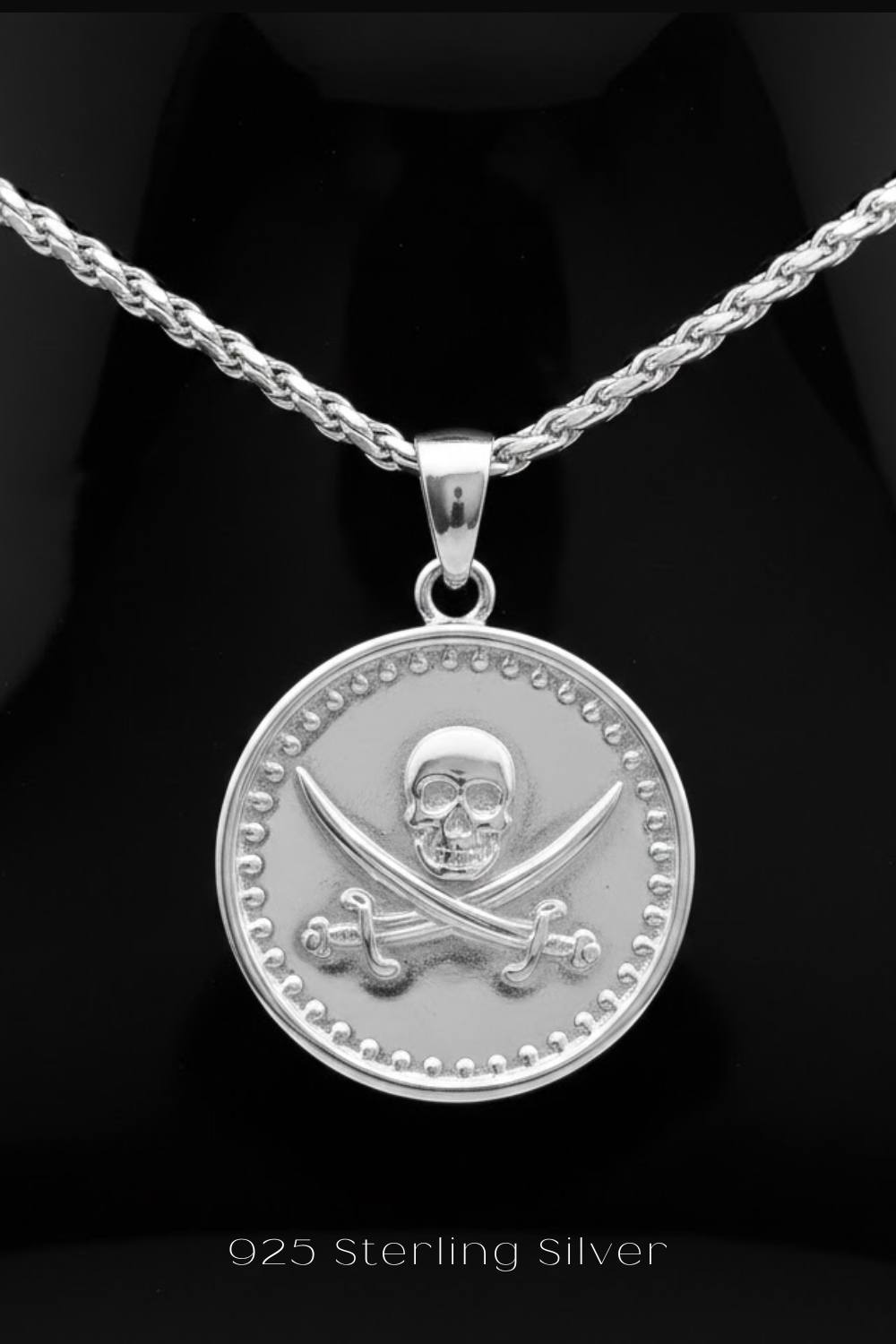 A silver-toned pendant necklace with a circular medallion featuring a skull and crossbones design.