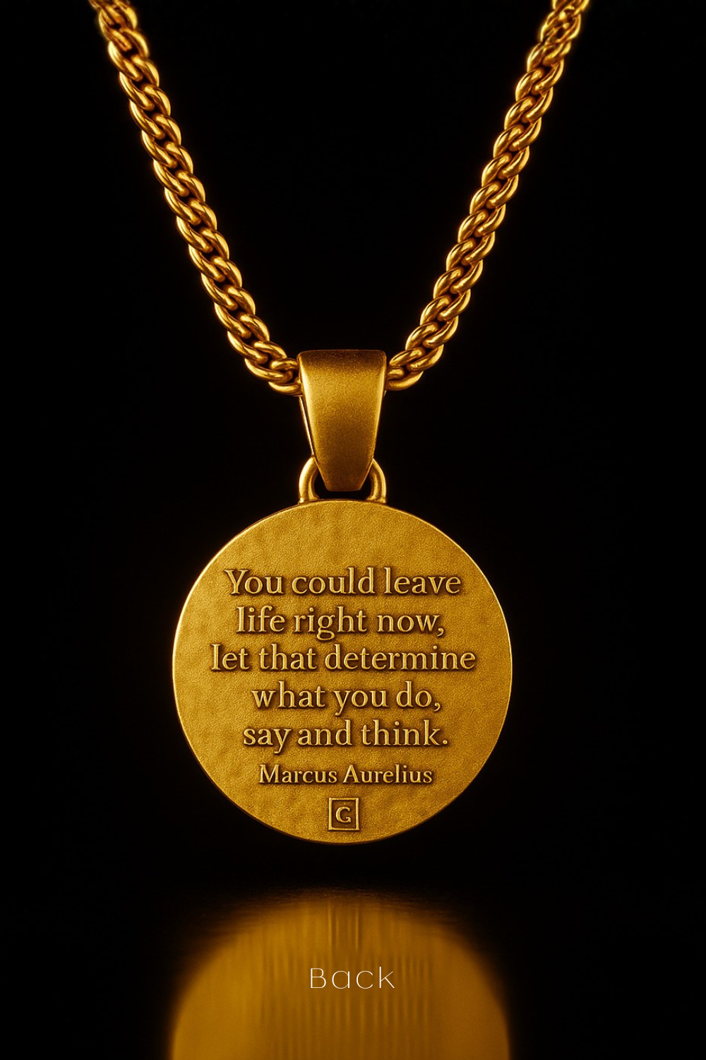 A gold-colored pendant necklace with a circular medallion featuring a quote by Marcus Aurelius.