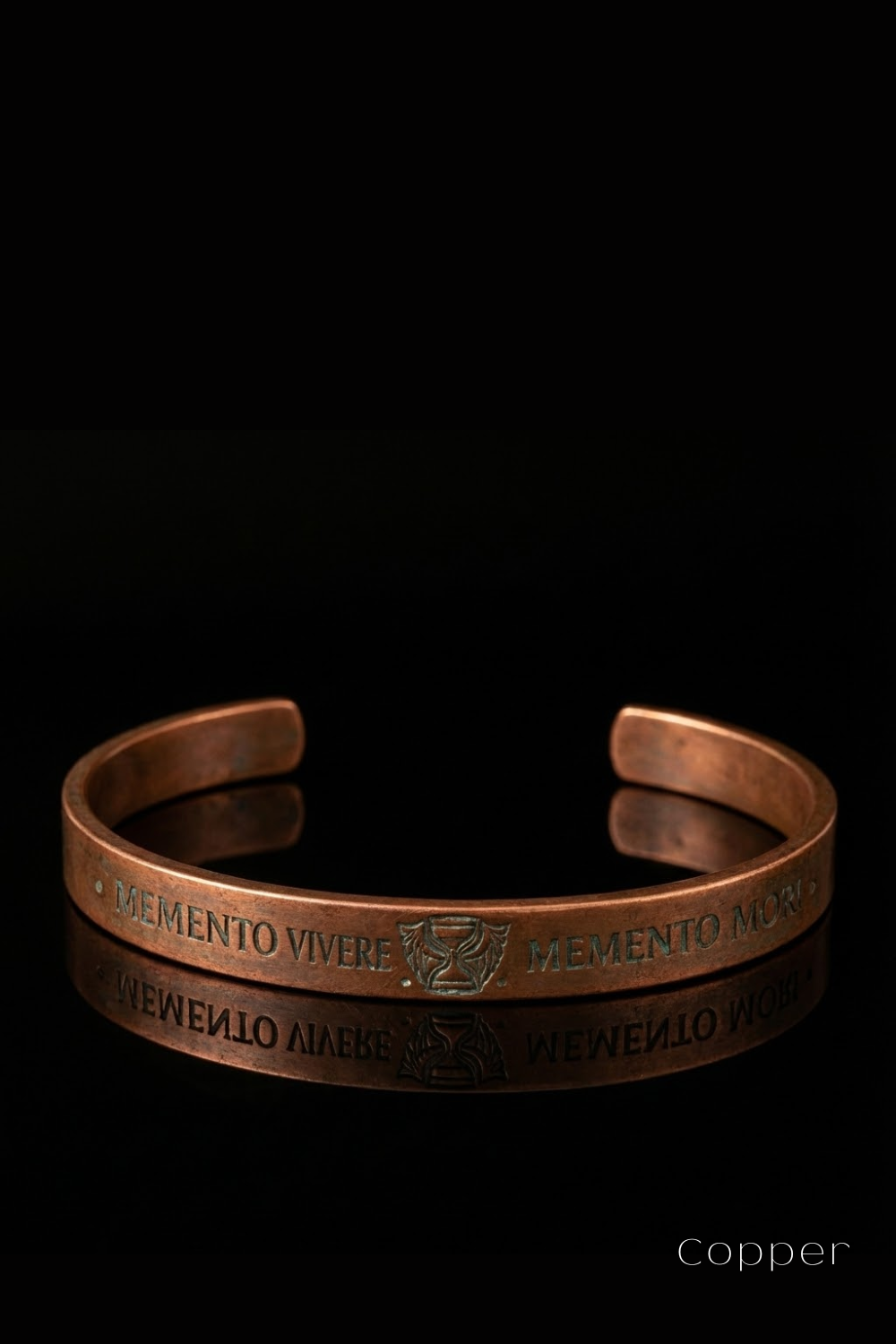 A copper bracelet with the engraved phrase "DEMENTO VIVERE MEMENTO MEMENTO MEMENTO" on it.