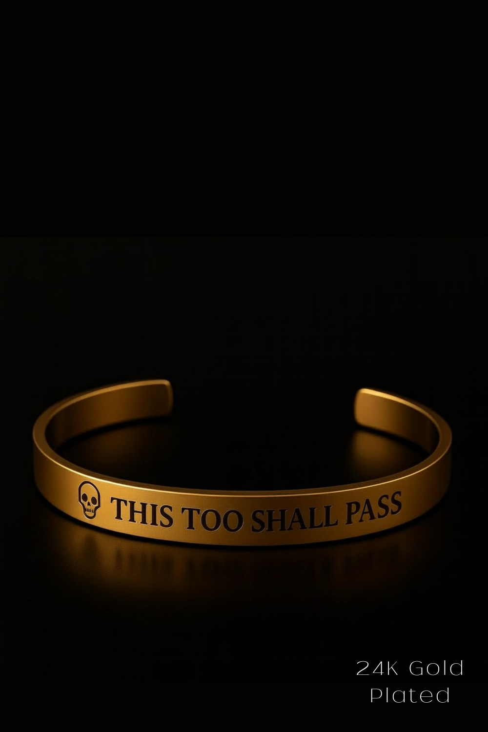 A gold-colored bracelet with the text "THIS TOO SHARE PASS" engraved on it, against a black background.