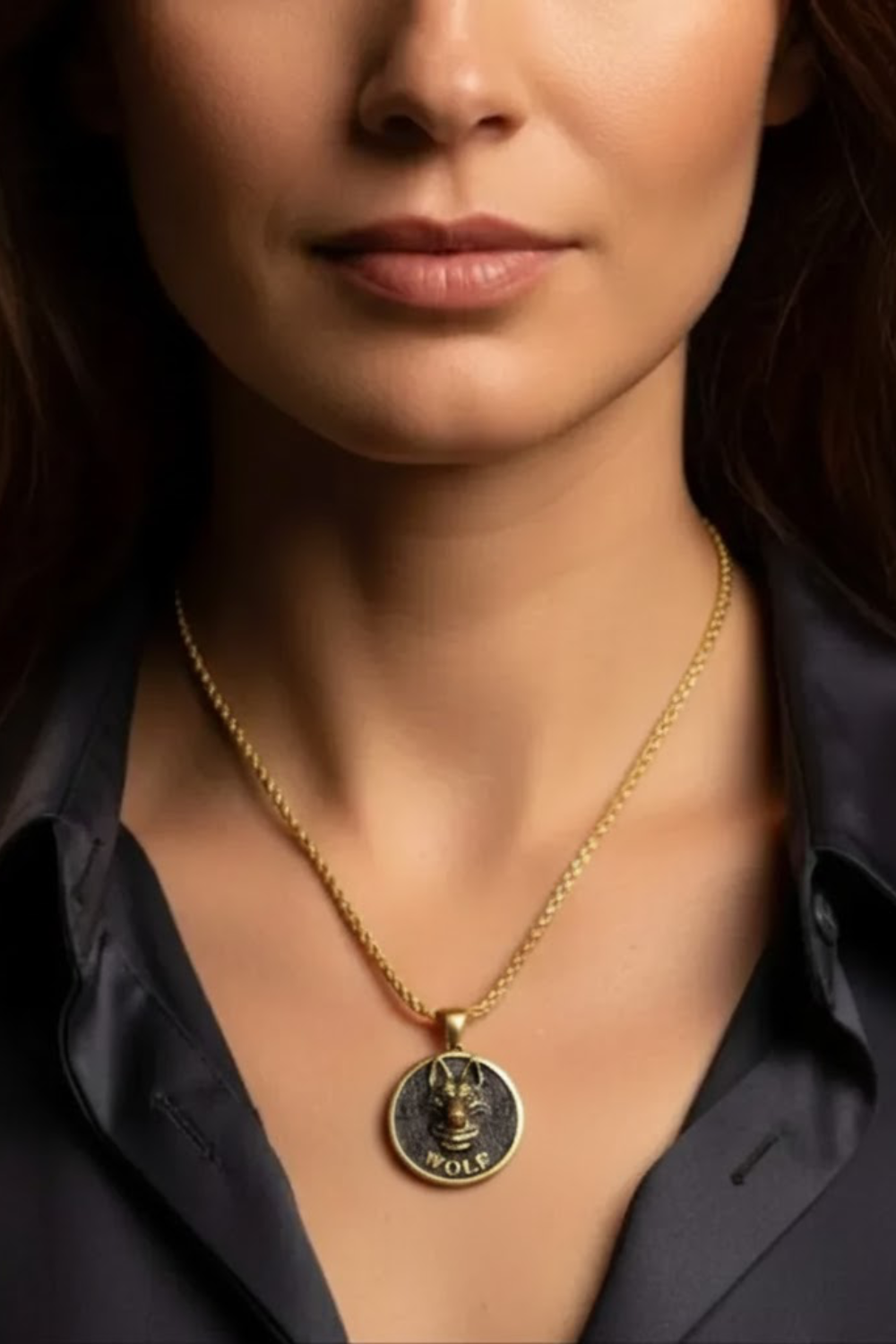 A close-up of a woman's neck and chest area, with a gold chain necklace and a pendant featuring a lion's head design.