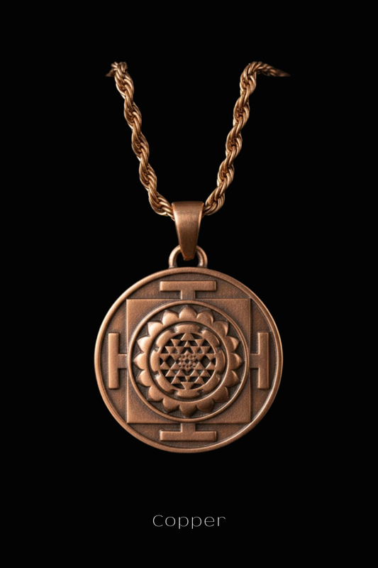 A copper-colored pendant with a geometric design, suspended from a rope chain against a black background.