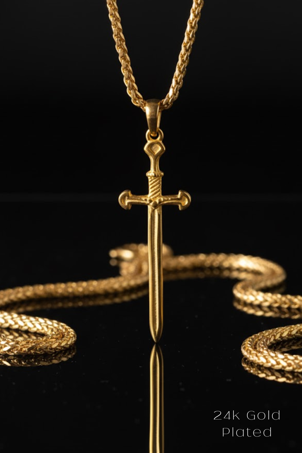 A 24K gold plated pendant featuring a sword design is displayed against a black background, with a chain visible in the foreground.