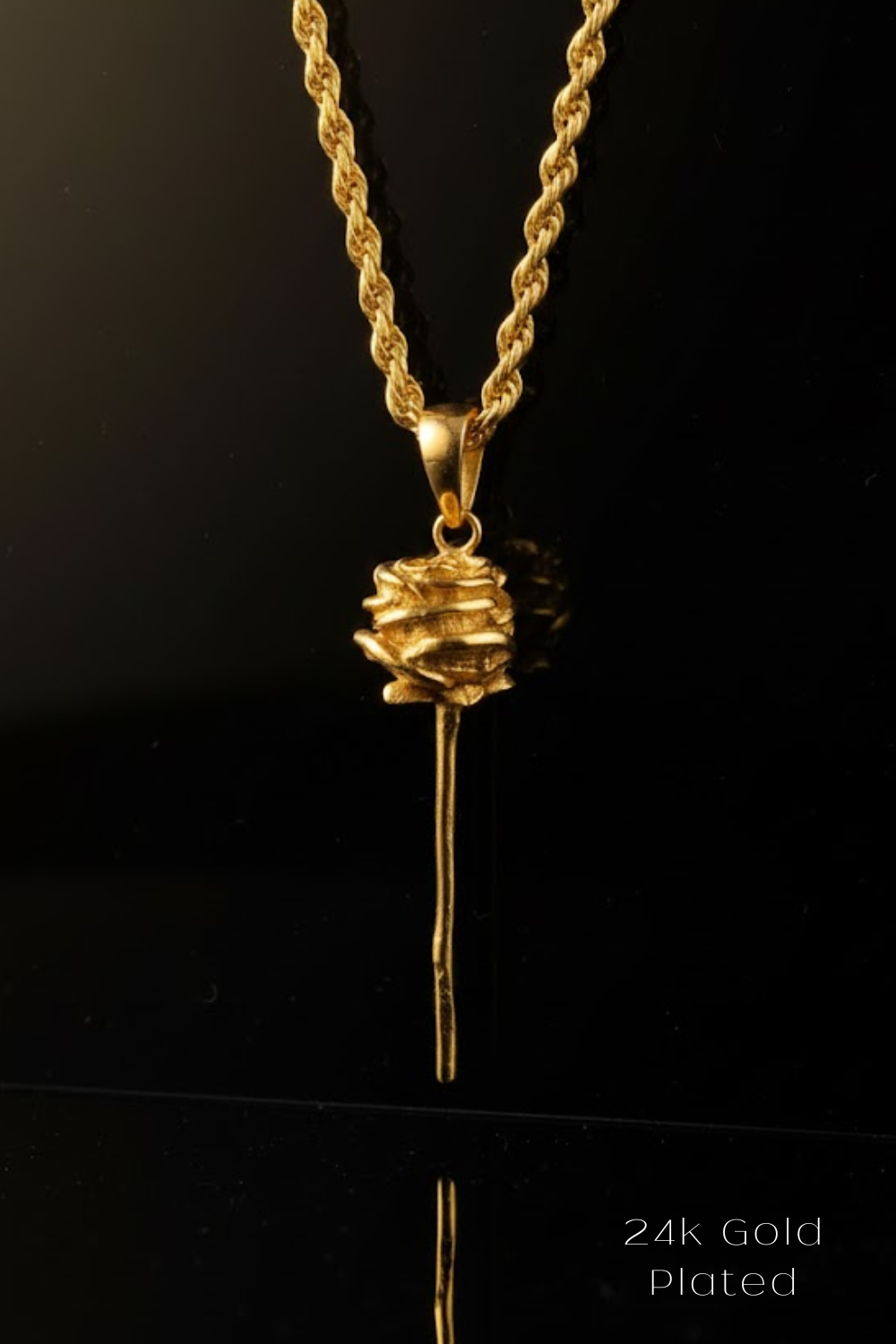 A 24k gold plated pendant necklace with a rose-shaped pendant is displayed against a black background.