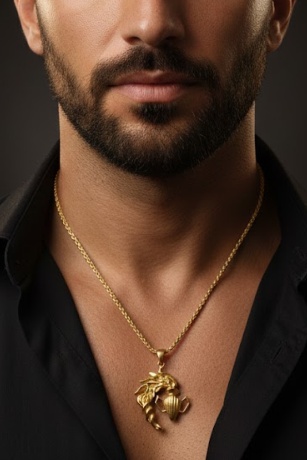 A close-up of a man's neck and chest area, with a gold-colored pendant necklace visible.