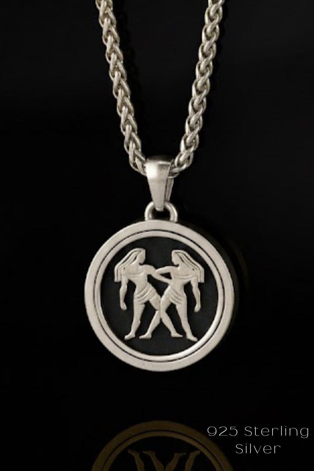 A silver pendant necklace with a circular pendant featuring a design of two women holding hands.