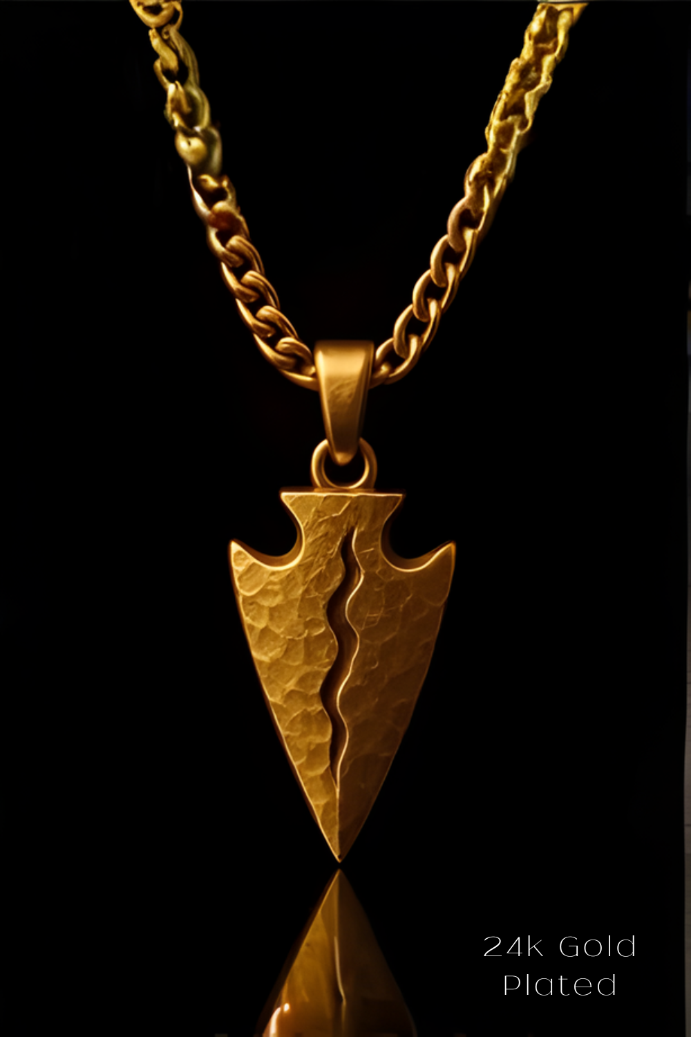 A 24k gold plated pendant featuring a split arrow design, set against a black background.
