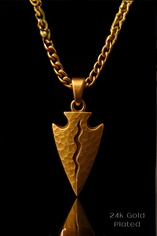 A 24k gold plated pendant featuring a split arrow design, set against a black background.