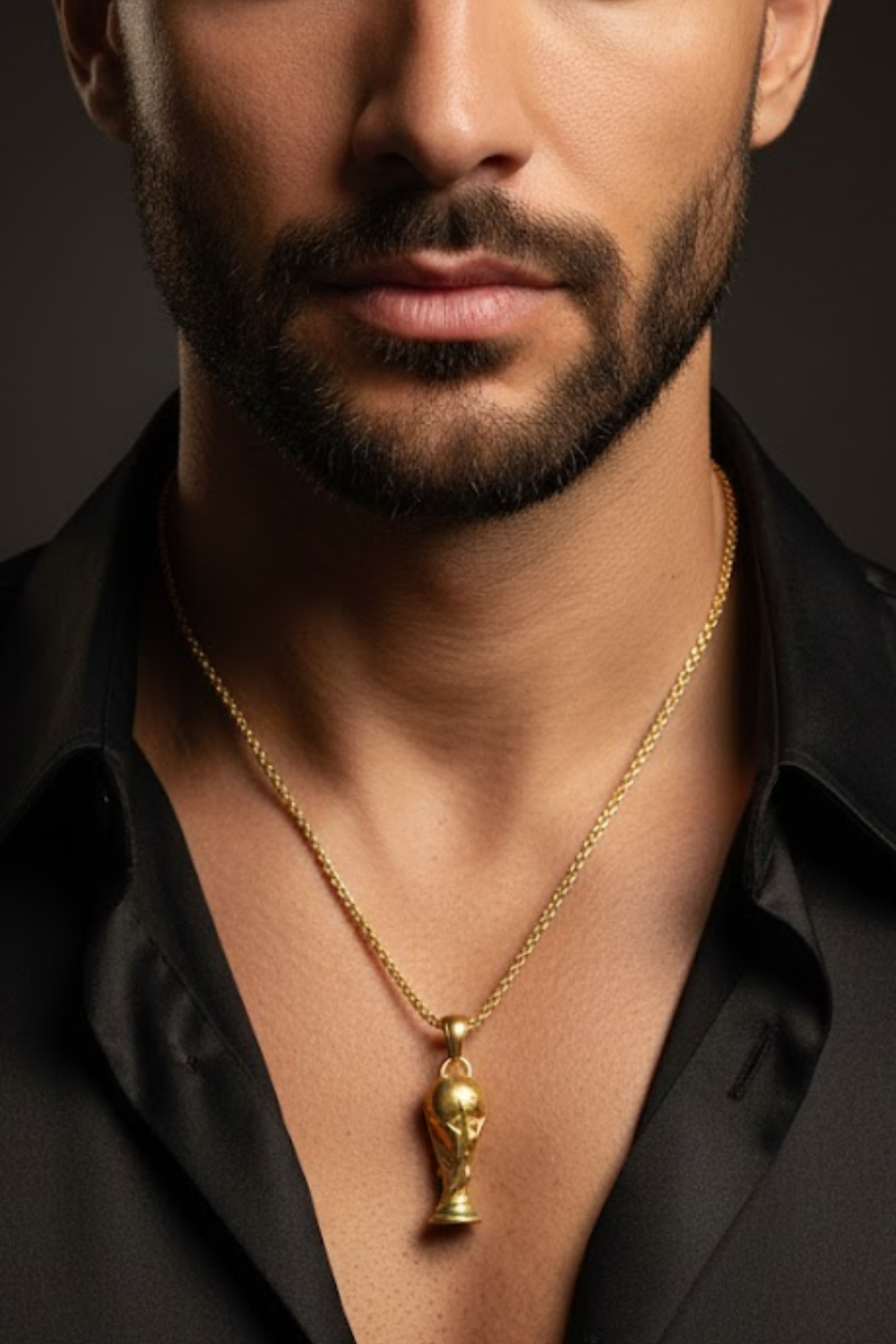 A close-up of a man's neck and chest area, with a gold-colored pendant necklace featuring a small trophy-like pendant.