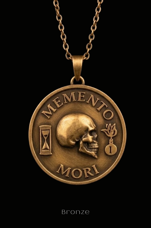 a bronze pendant necklace with a circular medallion design. The medallion has a skull and sand timer motif, and the text "MEMENTO MORI" is inscribed around the edge of the medallion.