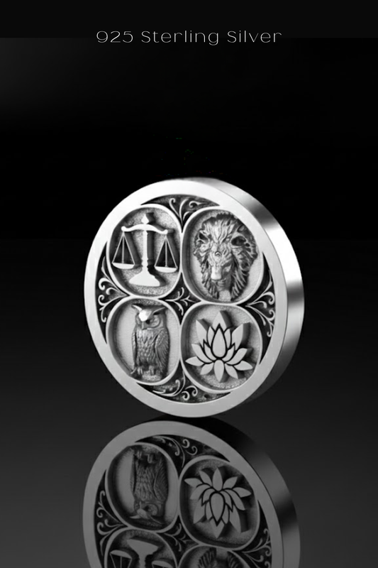 A silver coin with four distinct symbols, including an owl, a lion, a lotus flower, and a scale, arranged in a circular design.