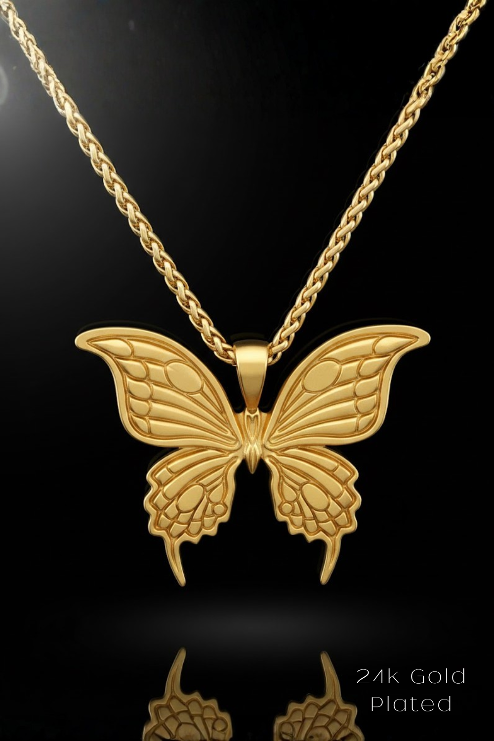 A 24k gold plated butterfly pendant necklace against a black background.