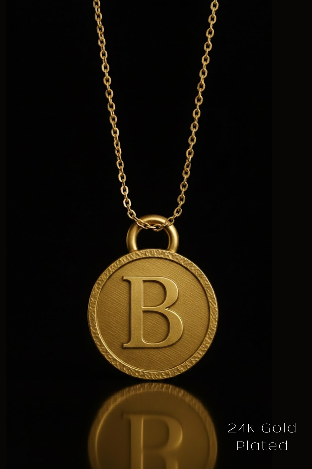 A 24K gold-plated necklace with a large circular pendant featuring the letter "B" in the center.