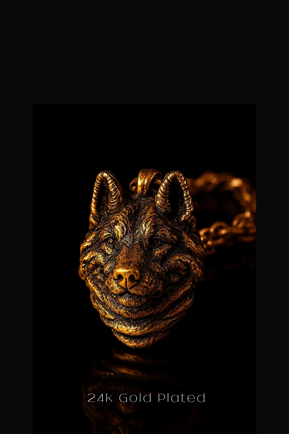 A close-up of a gold-plated wolf head pendant against a black background.