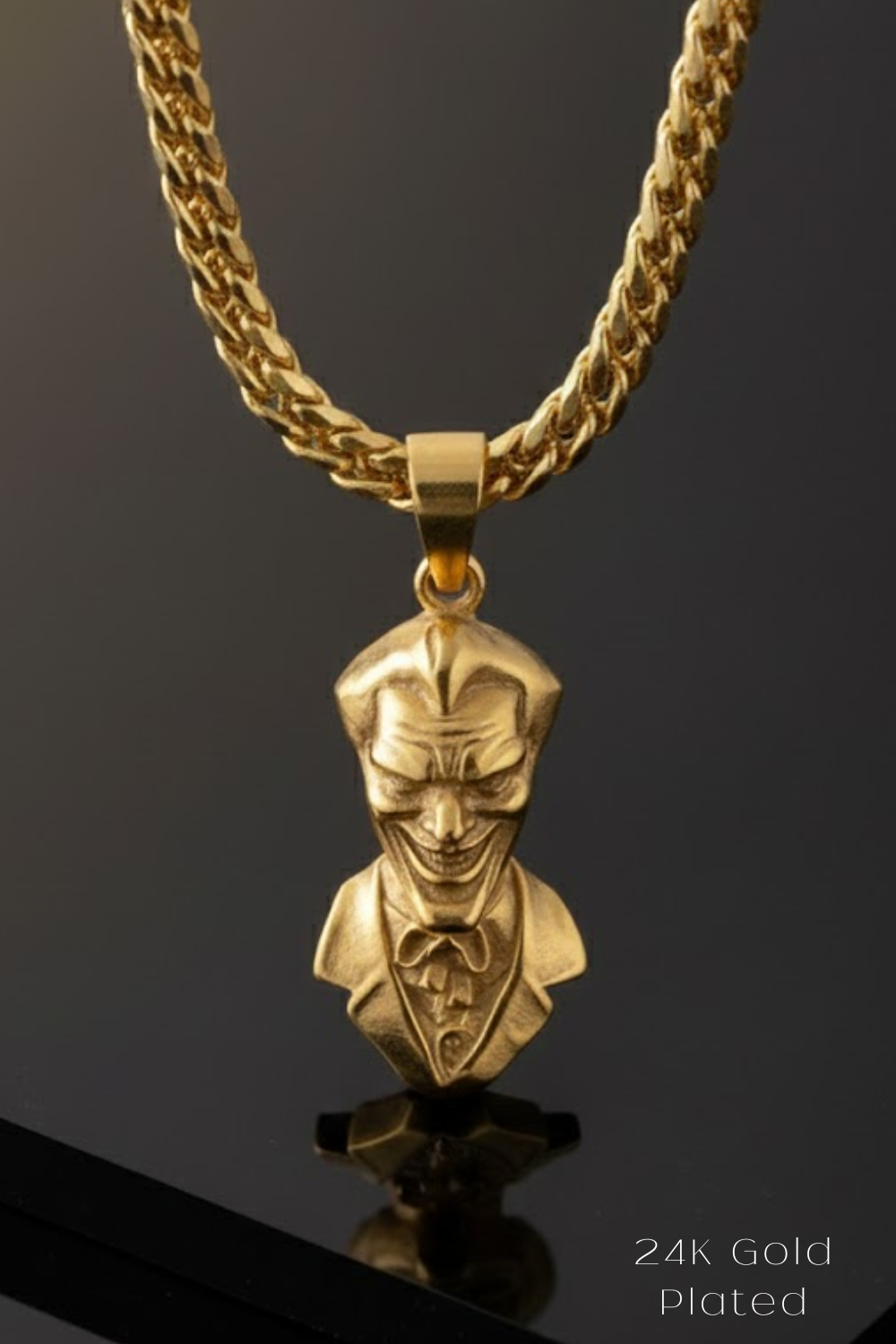A gold-colored pendant featuring a detailed bust of a person wearing a suit and tie, with a smiling expression.
