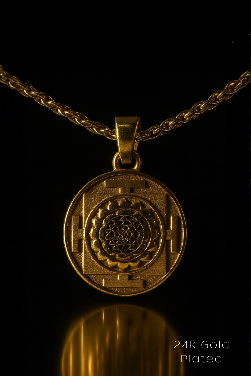 A 24K gold-plated pendant with a medallion design is displayed against a black background.