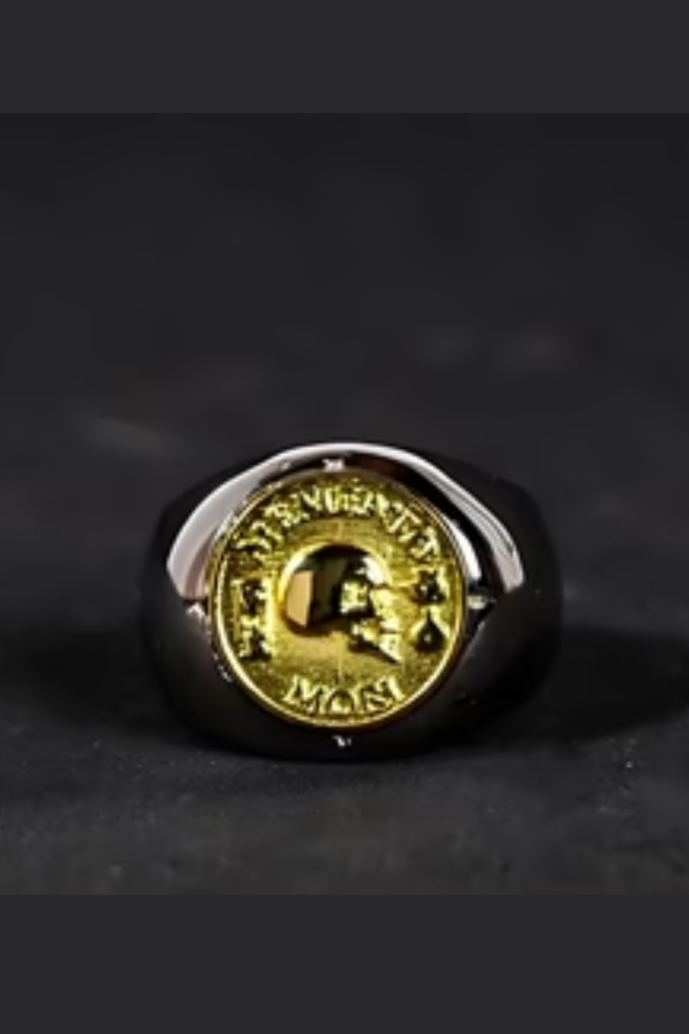 A ring with a gold-colored emblem featuring a skull and crossbones design.