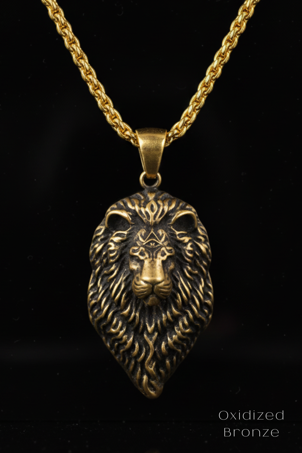 A gold-colored pendant in the shape of a lion's head, with intricate details and a chain around it.