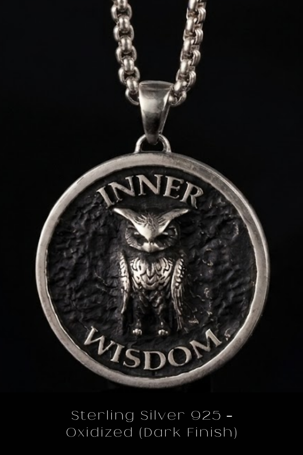 A silver pendant with an owl design and the words "INNER WISDOM" engraved on it.